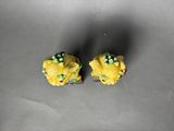 yellow cupcakes with peas and cheese on them sitting on a table