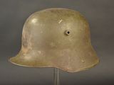 an old helmet on a metal stand against a gray background