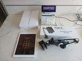 a table with a laptop, tablet, headphones, and other electronics on it