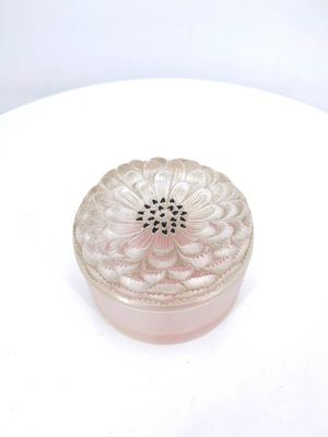 a small glass box on a white plate on a table