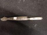 a silver spoon with a silver handle on a black surface