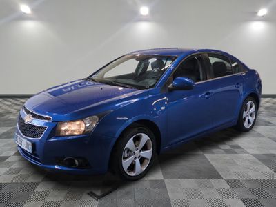 a blue chevrolet cruz parked in a garage with a checkered floor