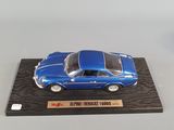 the model of a blue sports car is on a wooden stand