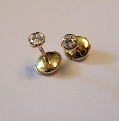 une paire de boucles d'oreilles en or et diamants sur fond blanc