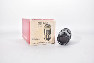 an old camera lens sitting on top of a box on a white surface