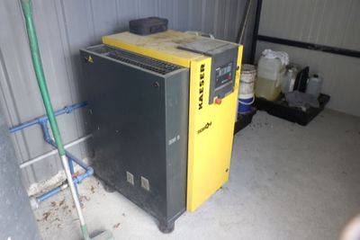 une photo d'un compresseur d'air jaune et noir dans un garage