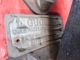 a close up of a metal license plate on a red vehicle