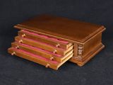 a small wooden box with pink drawers on a black background