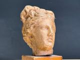 a statue of a woman ' s head on top of a wooden block
