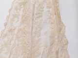 a woman in a wedding dress is standing on a white surface