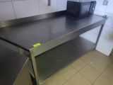 un micro-ondes posé sur un plan de travail en inox dans une cuisine