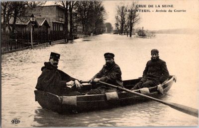 trois hommes dans une barque à rames dans une rue inondée