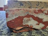 a close up of a piece of red and white marble