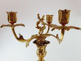 a gold candelab with three candles on it