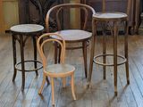 three chairs and a table in a room with wood floors