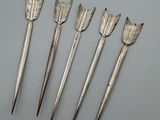cinq flèches argentées ornées de feuilles, sur un fond blanc