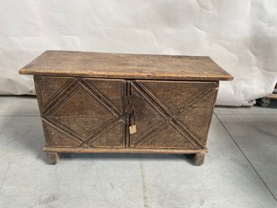 un vieux coffre en bois à deux portes et deux tiroirs