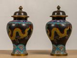 two vases with dragon designs on them sitting on a table