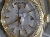 une montre-bracelet en or avec un cadran blanc