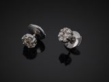 a pair of diamond stud earrings on a black surface