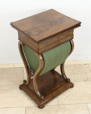 a small wooden table with a green cushion on it