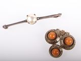 three pieces of jewelry including a broochle, a pearl and a broochle