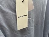 a close up of a person wearing a gray shirt with a tag on it