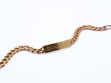 an image of a gold bracelet with a nameplate on it
