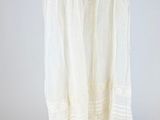 an image of a white dress hanging on a wooden hanger