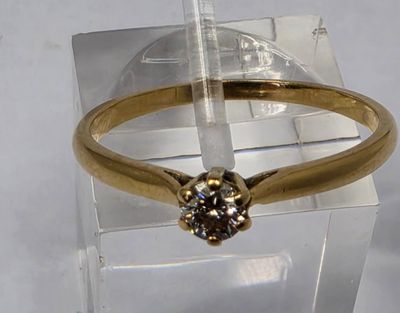 a gold ring with a brown diamond on top of it