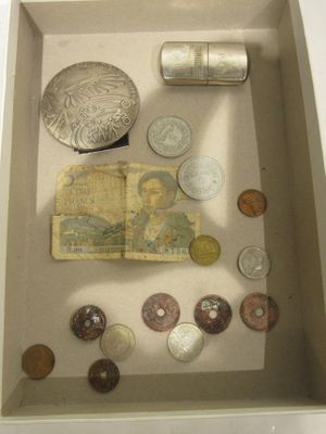 un cadre vitrine contenant des pièces de monnaie et d'autres objets