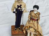 une figurine d'un homme et d'une femme assis sur un tapis