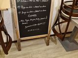 un tableau noir sur lequel est inscrit un menu, à côté de deux chaises