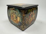 a black box with a painting on it on a white surface