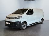 La camionnette blanche est garée dans une grande pièce équipée d'un ventilateur de plafond.