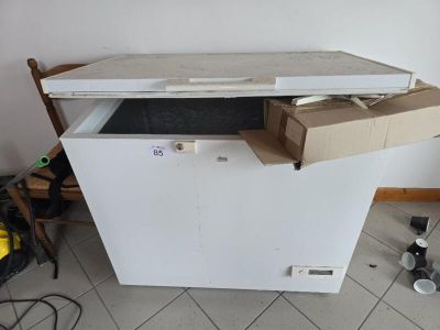 a white chest freezer sitting in the corner of a room