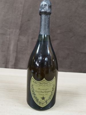 une vieille bouteille de champagne posée sur une table en bois, sur fond marron