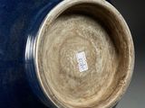 a blue vase sitting on a table with a tag on it
