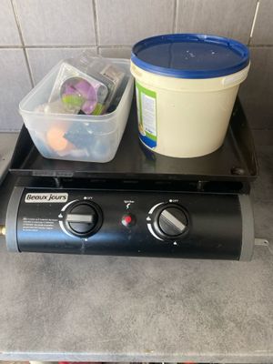 a black stove top with a container of food on top of it