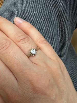 une main de femme portant une bague en diamant
