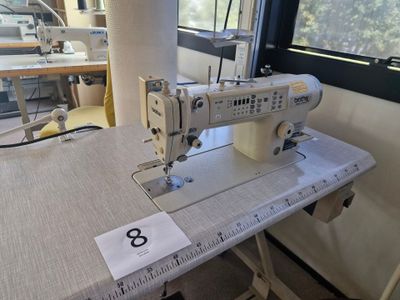 une machine à coudre posée sur une table dans une pièce