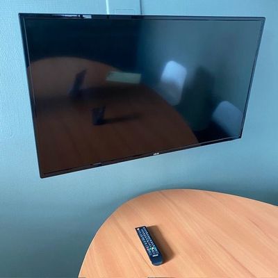 une télévision à écran plat accrochée au mur au-dessus d'une table