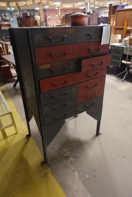 une photo d'une commode dans un atelier, avec une échelle