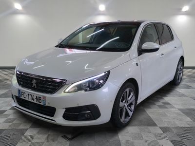 la voiture blanche est garée sur un sol en damier dans le garage