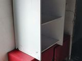 a red cabinet in the corner of a room next to a door