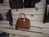 many bags and purses on the shelves in the store