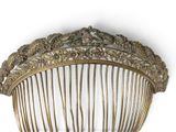 a gold comb that is sitting on a white surface