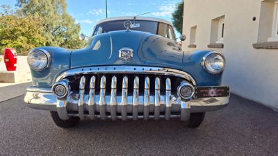 a blue car that is parked in front of a building
