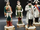 three figurines of men dressed in military uniforms stand in a row