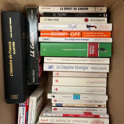 plusieurs livres empilés dans une boîte